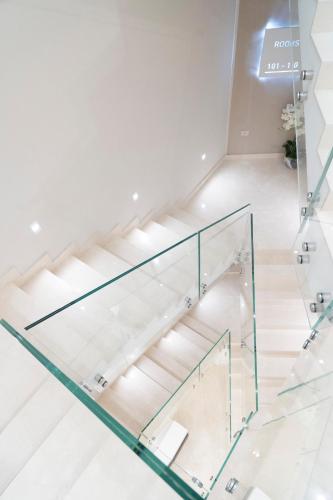 a glass stair case in a room with white walls at Amabile Luxury Rooms in SantʼAntonio Abate