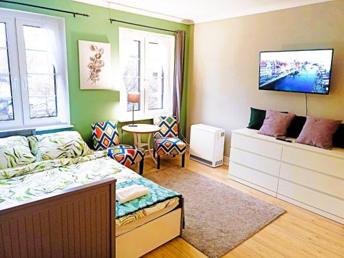 a bedroom with a bed and a tv on the wall at Brick Lane Apartment in Gdańsk