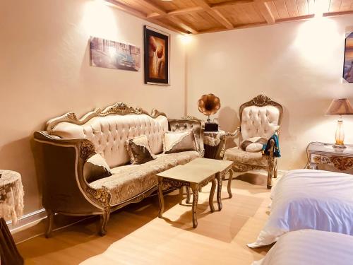 a bedroom with two chairs and a couch and a bed at بيتي بلس للغرف الفندقية- مدخل مستقل in Riyadh Al Khabra