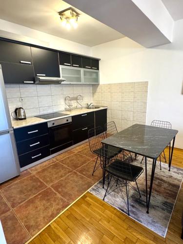una cucina con un tavolo e sedie in una stanza di Downtown Apartment a Skopje