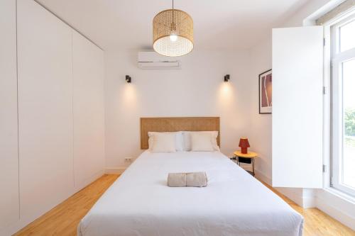a white bedroom with a large bed with white sheets at Sunny Lisbon Apartments by Soulplaces in Lisbon
