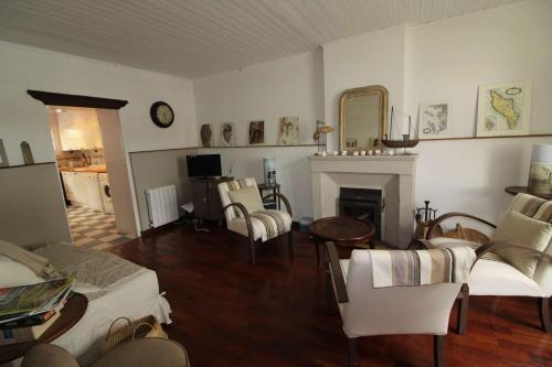 Elle comprend un salon doté d'un mobilier blanc et d'une cheminée. dans l'établissement Mais 5 pièces Oléron 8 couchages Saint Georges d'Oléron SGO000-905, à Saint-Georges-dʼOléron