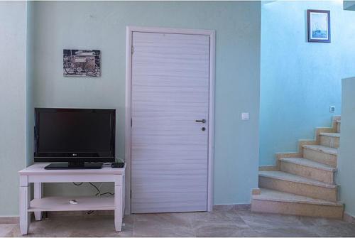 a white door in a room with a tv and a table at Aether & Gaia Seaview Villas, Agios Nikolaos #FeelsLikeHome in Akti Salonikiou