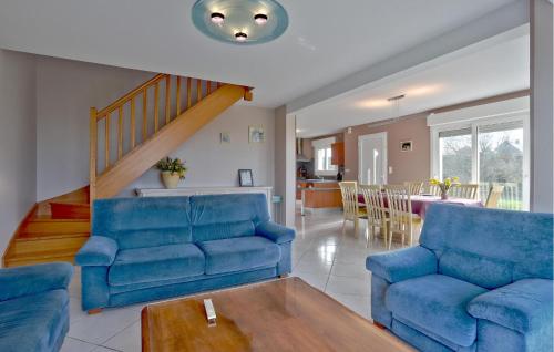 un salon avec deux chaises bleues et une table dans l'établissement 4 Bedroom Awesome Home In Courtils, à Courtils