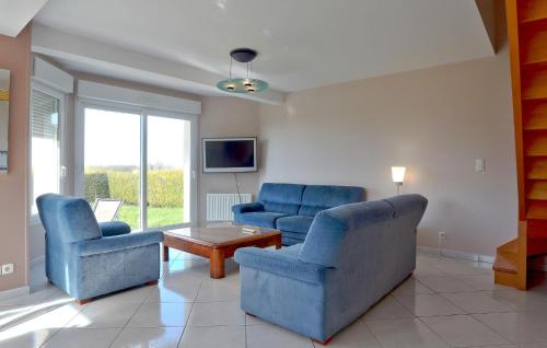 un salon avec des chaises bleues et une table dans l'établissement 4 Bedroom Awesome Home In Courtils, à Courtils