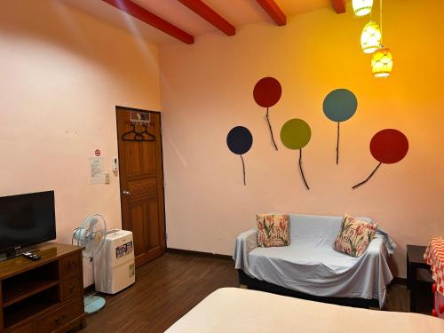 a room with a couch and a wall with balloons on it at Old Street Seaview Homestay in Jiufen
