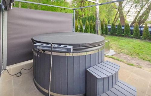a trash can and a bench on a patio at Stunning Apartment In Lubniewice in Lubniewice