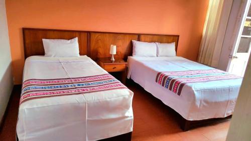 two beds sitting next to each other in a room at Casona Jerusalen in Arequipa