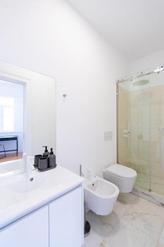 a white bathroom with a toilet and a sink at Sunny Lisbon Apartments by Soulplaces in Lisbon