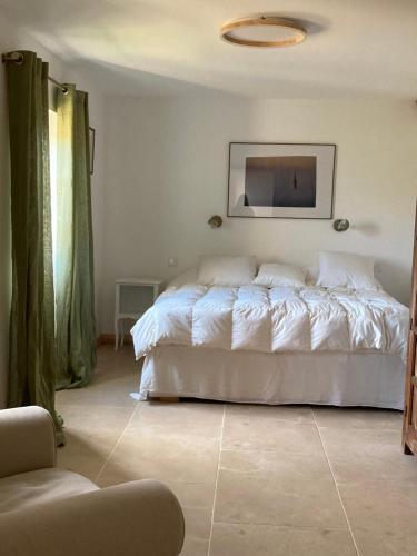 a bedroom with a white bed and a tv on the wall at Gîte de Rossignol in Cabanac-Séguenville