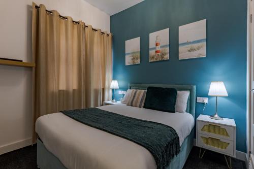a bedroom with a large bed with blue walls at STAY HUB City Centre - Self Check-in in Birmingham