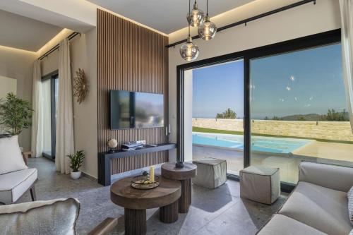 a living room with a view of a pool at Villa Lux Solis - With 2 Pools in Khoumérion