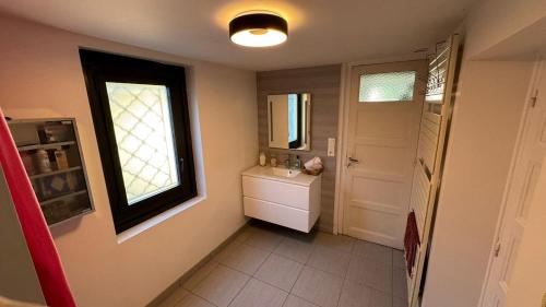 ein Badezimmer mit Waschbecken, Spiegel und Fenster in der Unterkunft Cosy Mary Queen - T4 - Maison avec piscine in Pau