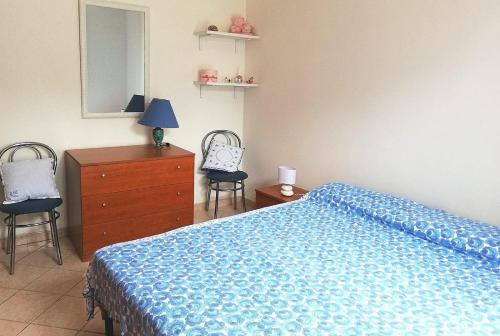 a bedroom with a bed and a dresser and two chairs at Casa vacanze morena in Sant'Isidoro