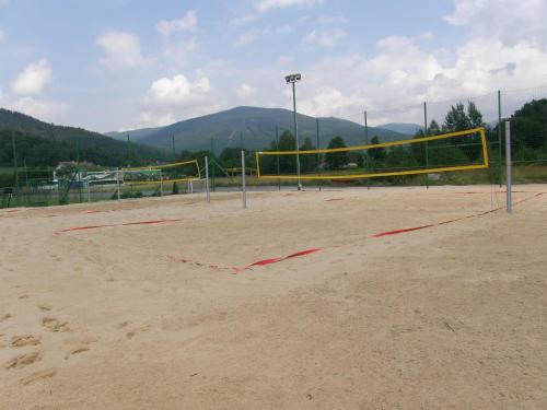 a volleyball court with a volleyball net in the sand at Relax Centrum Gól in Loučná nad Desnou