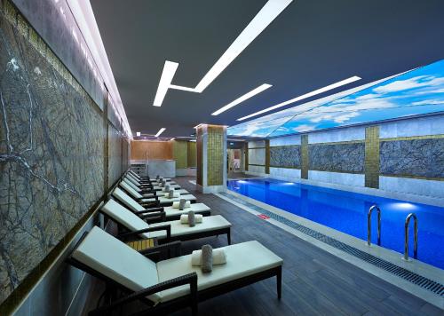 a hotel pool with tables and chairs and a swimming pool at Uranus Istanbul Topkapi in Istanbul