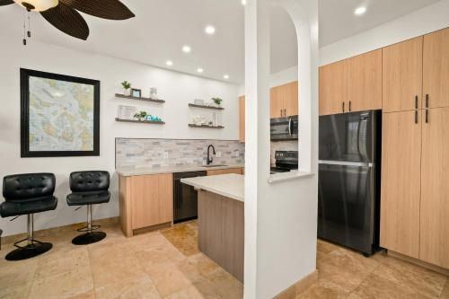 a kitchen with a refrigerator and a counter top at Hale Lolo at Poipu Kai in Koloa
