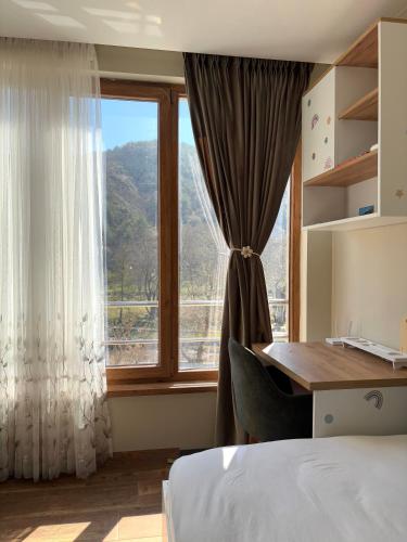 a bedroom with a desk and a large window at Luxury Park Villa in Sandanski