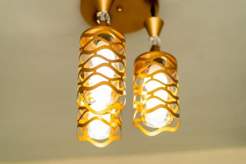a pair of gold and white earrings hanging from a wall at Lelesta in Bomet