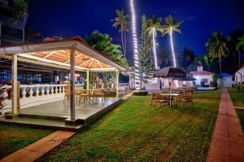 a gazebo with tables and chairs and palm trees at Close2C By The Arks Villa in Anjuna