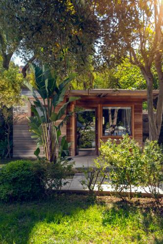 a small wooden house with a porch and trees at XUMA Bungalows in Bodrum City