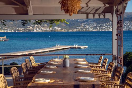 a long table with chairs and a view of the ocean at XUMA Bungalows in Bodrum City