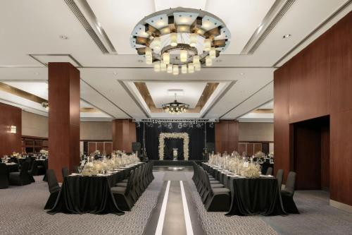 a banquet hall with tables and chairs and a chandelier at Sheraton Istanbul Levent in Istanbul