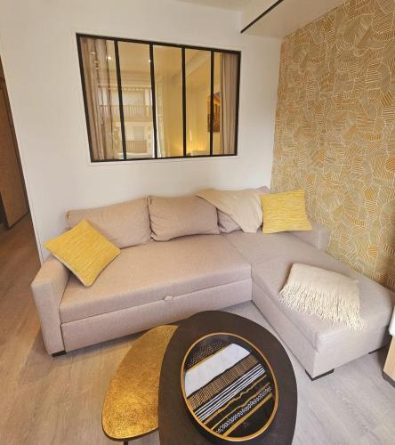 un salon avec un canapé et un miroir dans l'établissement Le Deauvillais Studio en plein cœur de Deauville, à Deauville