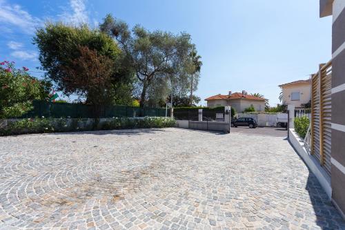 a driveway of a house with a fence at Villa Velvet in Villeneuve-Loubet