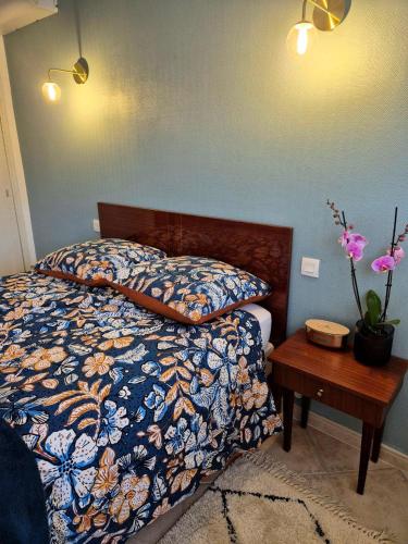 - un lit avec une couette colorée et une table en bois dans l'établissement Appart Hôtel French Riviera, à Saint-Raphaël