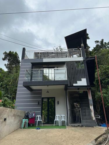 ein Haus mit einem Balkon und Hockern davor in der Unterkunft K and R Apartment Fully Furnished Home with Balcony in Carcar