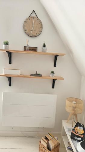 a shelf on the wall with a clock on it at L'escale cosy in Dinan