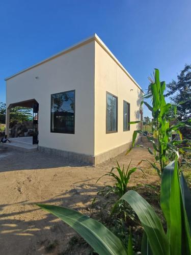 a house on the beach with a building at Bianca's Cottage - Whole House in Mikumi