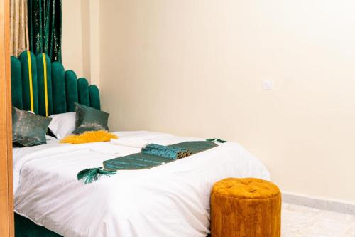 a bedroom with a bed with white sheets and a stool at Lelesta in Bomet