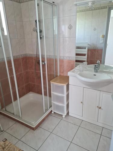 une salle de bain avec douche et lavabo dans l'établissement maison face à la mer, à Trégunc