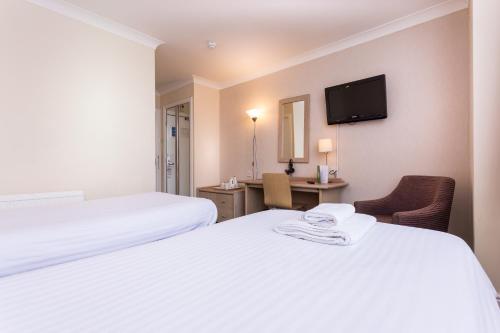 a hotel room with two beds and a tv at The Gardens Hotel in Manchester