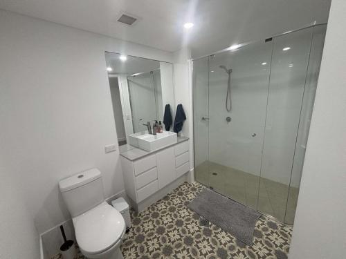 a bathroom with a toilet and a sink and a shower at Seaside Sovereign Retreat in Caloundra