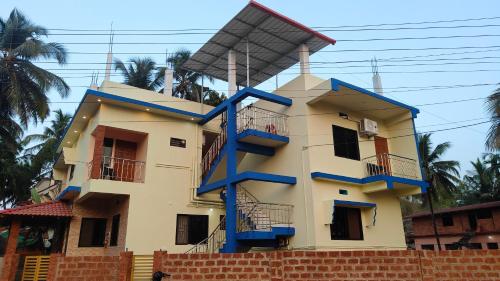 a house with a blue staircase on it at Kahani Home Stay in Gokarna