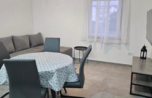 un salon avec une table et un canapé dans l'établissement Apartman Jim, à Vir