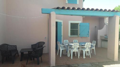 un patio avec une table et des chaises et une cuisine dans l'établissement ST CYPRIEN C17, à Porto-Vecchio