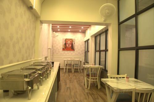 a dining room with tables and chairs and a painting on the wall at Subhash Hotel in Prayagraj