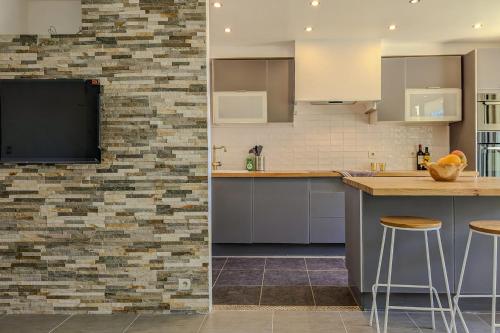 une cuisine avec des placards blancs et un mur en briques dans l'établissement Apartment for 8 guests in Nice city center, à Nice