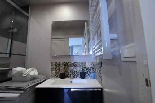 - une petite cuisine avec un évier et un miroir dans l'établissement First floor apartment fully renovated, à Antibes