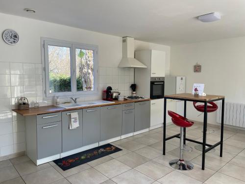 une cuisine avec un comptoir et une table à l'intérieur dans l'établissement Les jardins de jodie, à Saint-Aubin-de-Branne