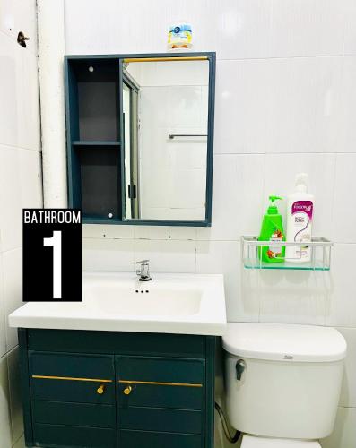 a bathroom with a sink and a mirror and a toilet at The Pine Lodge- Bukit Tinggi Klang in Klang