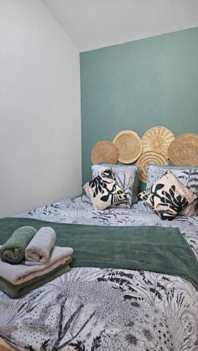 a bed with hats and pillows on top of it at L'escale cosy in Dinan