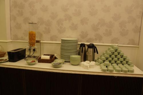 a table with cups and plates and dishes on it at Subhash Hotel in Prayagraj