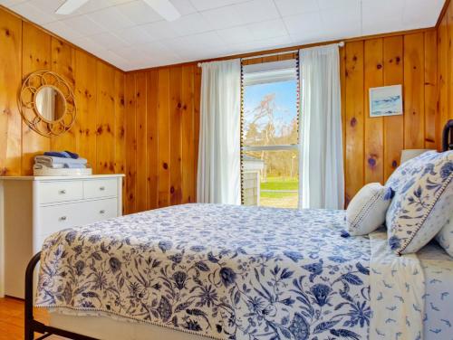 a bedroom with a bed and a window at Spinneys Guesthouse & Beach Cottages in Phippsburg