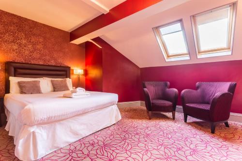a bedroom with a bed and two chairs at The Gardens Hotel in Manchester