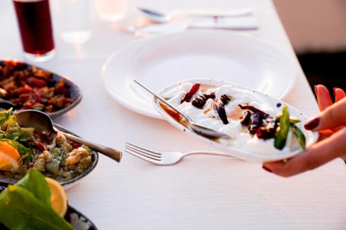 a person holding a plate of food on a table at Hotel Delta in Fethiye